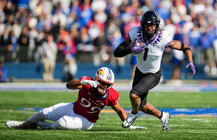 Oct 8, 2022; Lawrence, Kansas, USA; TCU Horned Frogs wide receiver Quentin Johnston (1) runs with the ball past Kansas Jayhawks defensive lineman Malcolm Lee (99) during the first half at David Booth Kansas Memorial Stadium. Mandatory Credit: Jay Biggerstaff-USA TODAY Sports